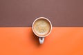 Top view of a fresh espresso cup on orange and brown split background Royalty Free Stock Photo