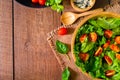 Top view of fresh green vegetable with red cherry tomato, onion and spinach with lettuce. Salad sesame dressing in wood bowl. Royalty Free Stock Photo