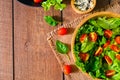 Top view of fresh green vegetable with red cherry tomato, onion and spinach with lettuce. Salad sesame dressing in wood bowl. Royalty Free Stock Photo