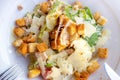 Top view of fresh healthy Caesar salad with grilled chicken breast in a big white plate with fork and knife aside. Royalty Free Stock Photo