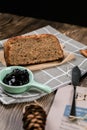 Top view fresh homemade banana bread and sliced bread on cutting board with jam strawberry and blueberry on wooden background.Heal