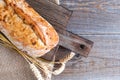 Top view of fresh homemade ciabatta with wheat ears lying on a wooden board. Traditional Italian bread. Bakery products. Place for Royalty Free Stock Photo