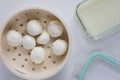 Top view of fresh homemade mozzarella balls on strainer close to whey to store cheese