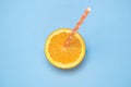 Top view of fresh orange fruit slice with drinking straw isolated on blue Royalty Free Stock Photo