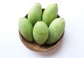 Fresh organic Barracuda mangoes fruit in a beautiful Thai wicker on white background in Thailand. Tropical fruit in thailand.