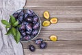 Closeup of plums in a bowl on wooden background. Top view. Royalty Free Stock Photo