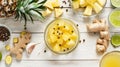 Top view of fresh pineapple chunks, ginger, lime, and spices on a wooden table. Royalty Free Stock Photo