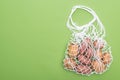 Top view of fresh potatoes in eco friendly string bag isolated on green. Royalty Free Stock Photo