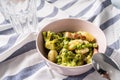 Top view on fresh prepared broccoli with gnocchi in bowl on the table - homemade healthy food in bright light with copy space