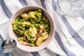 Top view on fresh prepared broccoli with gnocchi in bowl on the table - homemade healthy food in bright light with copy space