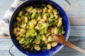 Top view on fresh prepared broccoli with gnocchi in casserole dish on the wooden table - homemade healthy food in bright light