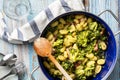 Top view on fresh prepared broccoli with gnocchi in casserole dish on the wooden table - homemade healthy food in bright light