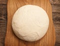 top view fresh raw dough for pizza or bread baking on wooden cutting board Royalty Free Stock Photo