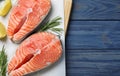 Top view of fresh raw salmon with lemon and rosemary on wooden table, space for text. Fish delicacy Royalty Free Stock Photo