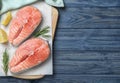 Top view of fresh raw salmon with lemon and rosemary on wooden table, space for text. Fish delicacy Royalty Free Stock Photo