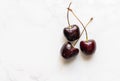 Top view fresh red cherries on marble floor, flat lay design, group of three fresh red cherries, small water drop on the fruit Royalty Free Stock Photo