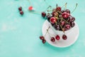 Top view of fresh red cherries in a white cup, on azure background. Healthy diet, weight loss or hello summer concept Royalty Free Stock Photo