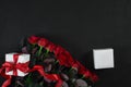 Top view fresh red rose flower and gift boxes on black deck with empty space for design. For love or valentine day Royalty Free Stock Photo