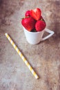 Top view of strawberries in a white cup on wooden background Royalty Free Stock Photo