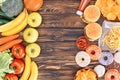 top view of fresh ripe fruits with vegetables and assorted junk food on wooden table Royalty Free Stock Photo