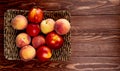 top view of fresh ripe nectarines and peaches on a wicker tray on wooden rustic background with copy space Royalty Free Stock Photo