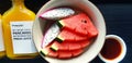 Top view of Fresh sliced of watermelon and dragon fruit in plate with bottle of orange juice on black wooden table Royalty Free Stock Photo