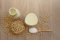 Top view, fresh soybean seeds in brown wooden bowl with sugar in a spoon, a bottle and a glass of soy milk on the wood table Royalty Free Stock Photo