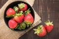 Top view fresh strawberries in a bowl on wooden background.