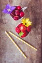 Top view of strawberries, cherries and flowers in bowls on wooden background Royalty Free Stock Photo