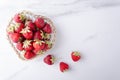 Top view fresh strawberries in the heart shape bowl on the white surface Royalty Free Stock Photo