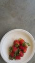 Top view of fresh strawberries in plate on rustic white wood background Royalty Free Stock Photo