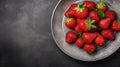 Top of view fresh strawberry in wrought plate on concrete board