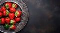 Top of view fresh strawberry in wrought plate on concrete board