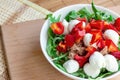 Top view of fresh summer vegetables and green herbs, red pepper, arugula, canned tuna and mozzarella as a salad in the white bowl Royalty Free Stock Photo