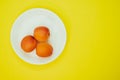 Top view of fresh three apricots on a plate isolated on yellow background Royalty Free Stock Photo