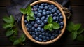 European blueberry and green leaves in a wooden bowl