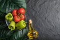 Top view of fresh vegetables, tomato and pepper in glass bowl and bottle of oil