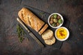 Loaf of bread with spicy olive oil and old rusty table-knife Royalty Free Stock Photo