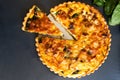 Top view freshly bake leek bacon spinach quiche on dark background