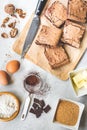 Top view of freshly baked home made brownie cake arranged with recipe ingredients over white rustic background Royalty Free Stock Photo