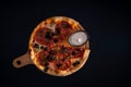 Top view of a freshly baked pizza with salami peppers olives and sauce on a wooden tray Royalty Free Stock Photo