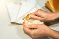 Top view of freshly bread loaf being open by female hands with a piece of brie cheese in the background on top of the counter Royalty Free Stock Photo