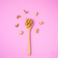 Top view fried cashew nut with salt on pink background. Copy space for text or design