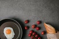 top view of fried egg on frying pan, fresh tomatoes and baguette in paper bag on grey Royalty Free Stock Photo