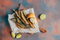 Fried fish, beer, baguette, lemon on concrete background