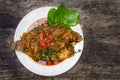 top view Fried Nile tilapia fish with red curry paste on white plate wooden background, Thai food is spicy mixed with sweet flavor Royalty Free Stock Photo