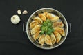 Top view of fried pot stickers, dumplings, and celery in a pan, black background Royalty Free Stock Photo