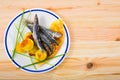 Top view of fried sardines with potato on wooden background