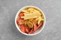 Top view of fried sausage, french fries and pickled cucumber in cardboard bowl Royalty Free Stock Photo