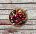 Top view. Fruits and berries in bowl on wooden background. Ripe currants, raspberries, cherries, strawberries, gooseberries, black Royalty Free Stock Photo